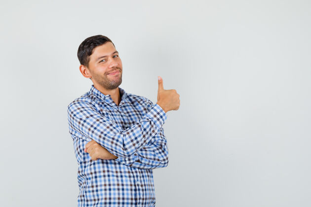 微笑年轻的男人穿着格子衬衫竖起大拇指 看起来很快乐生活方式男人虚拟