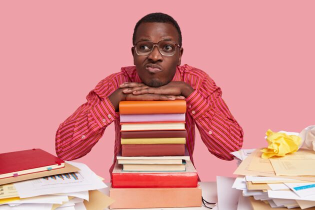 书籍无聊不快乐的非洲裔美国人有着不悦的表情 噘起嘴唇 有着深思熟虑的表情 思考着新的创新方案思考周到考试