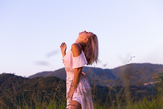 自然穿着夏装的年轻白种女人的浪漫肖像 在山上的公园里享受放松 美丽的热带海景 度假的女人 在泰国旅游日落时的快乐女人优雅紫色配饰