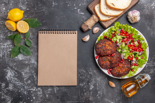 肉片俯视图美味的肉排配色拉和面包 背景为灰色的菜肴照片美食新鲜午餐食物