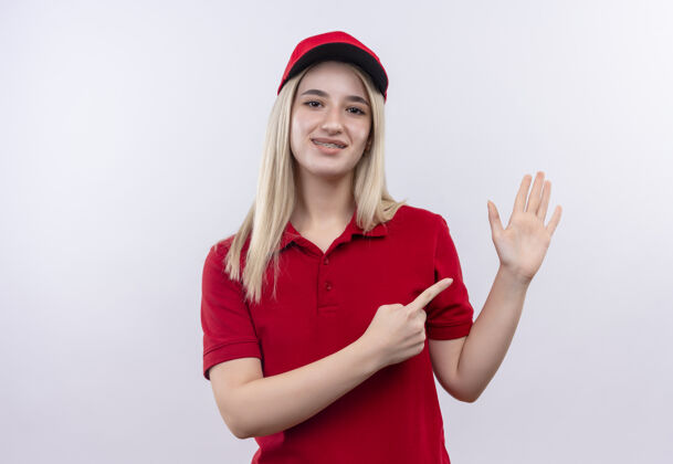 帽子微笑交货的年轻女孩穿着红色t恤和帽子在牙科支撑点在手上孤立的白色背景T恤穿着白色