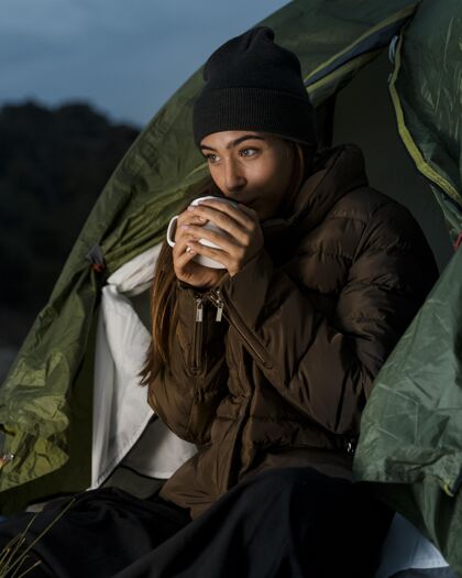 户外女人露营 喝一杯茶旅行者体验乡村