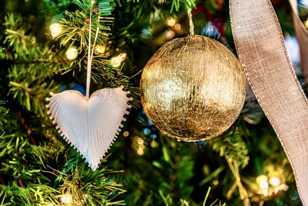 传统美丽的特写一个白色的心形装饰和圣诞树上的金球木制欢乐绿色