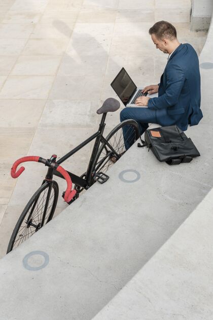 骑自行车的在自行车旁操作笔记本电脑的人享受健康休息