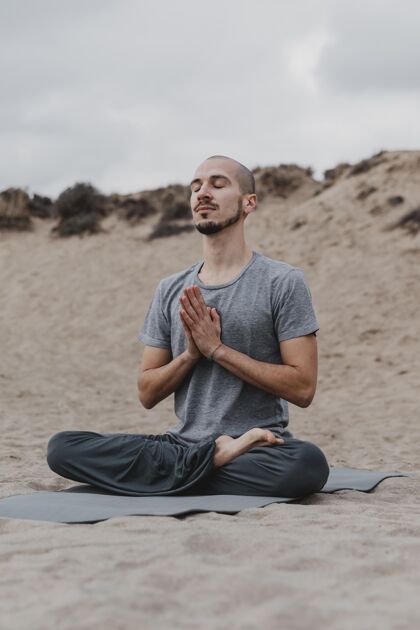 冥想男人一边做瑜伽一边在户外冥想专注户外男性