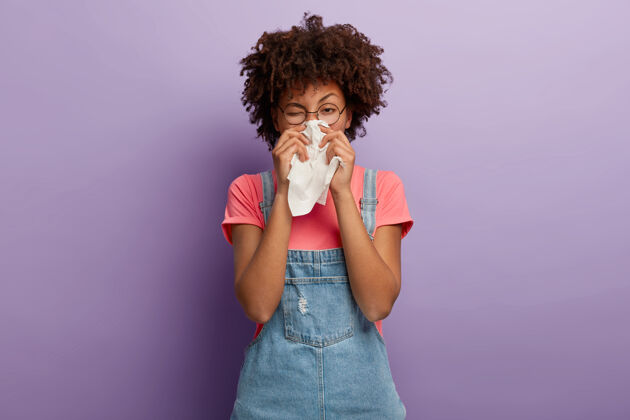 感染非洲裔美国妇女在白色组织中打喷嚏 患有鼻炎和流鼻涕病毒发型保健