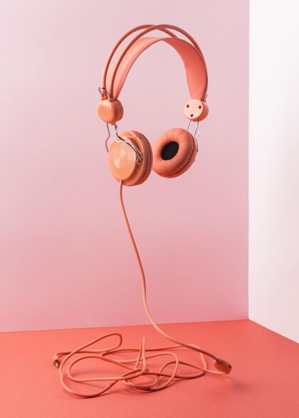 安排粉色耳机与电缆飞布局静物艺术