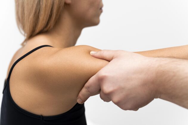 理疗师理疗师按摩妇女手臂的侧视图女性治疗治疗学