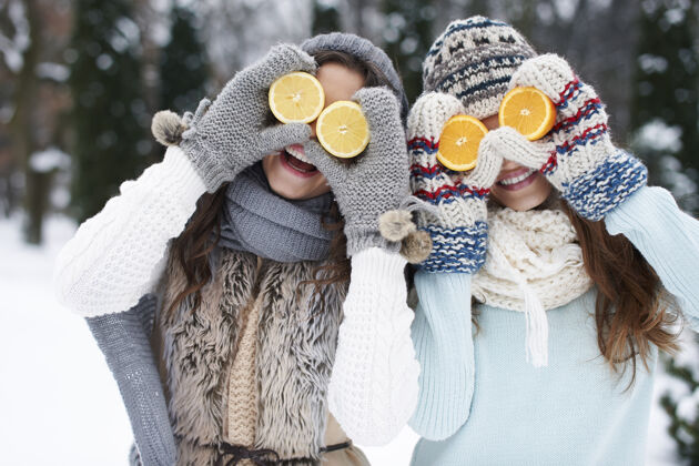 牙齿微笑有趣的女孩与天然维生素在冬天毛衣衣服新鲜