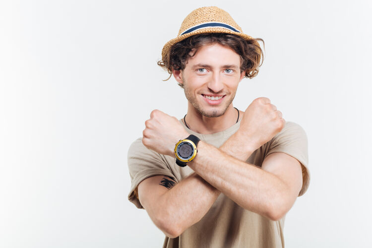 抱着在白色背景上 一个年轻时尚的男人交叉双臂 做着停下来的手势帽子执行男性