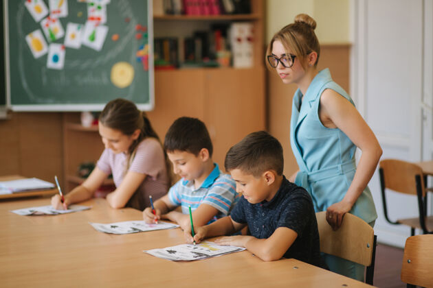 室内老师在课堂上帮助学生进行写作测试教育 小学 学习和生活小学孩子教育
