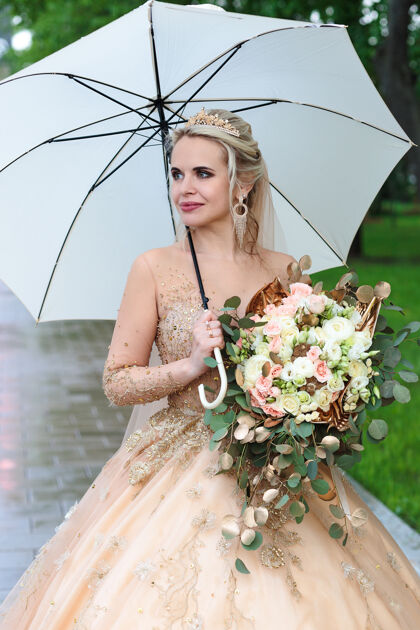 雨伞幸福的新娘打着白色雨伞 在夏天的公园里露天婚礼夫妇季节关系