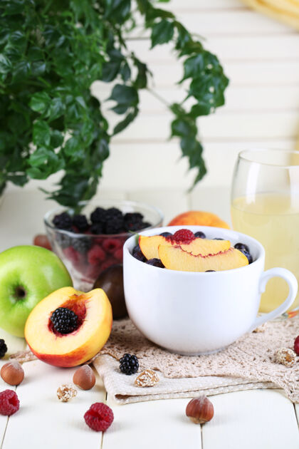 浆果麦片在杯子里 浆果放在餐巾上 木桌上亮晶晶的李子传统健康