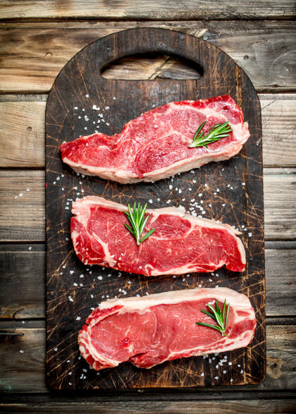 牛排原汁原味的大理石牛肉牛排配上盐和香料放在乡村的桌子上蛋白质俯视图牛肉