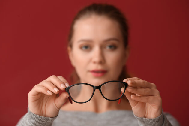 持有视力不好的年轻女子拿着眼镜成人眼科光学
