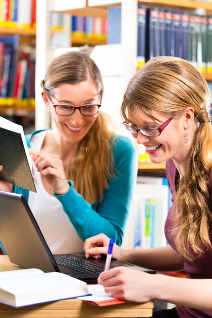 大学学生-年轻女性在图书馆与笔记本电脑和书籍学习小组智力高加索女性