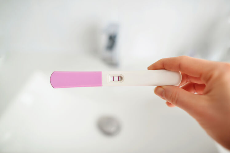 期望特写女人在浴室里手握怀孕测试 保健理念 选择性聚焦青少年医学怀孕