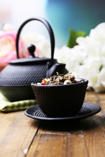 热黑色茶壶 碗和芙蓉茶放在彩色木桌上 背景明亮古代文化传统