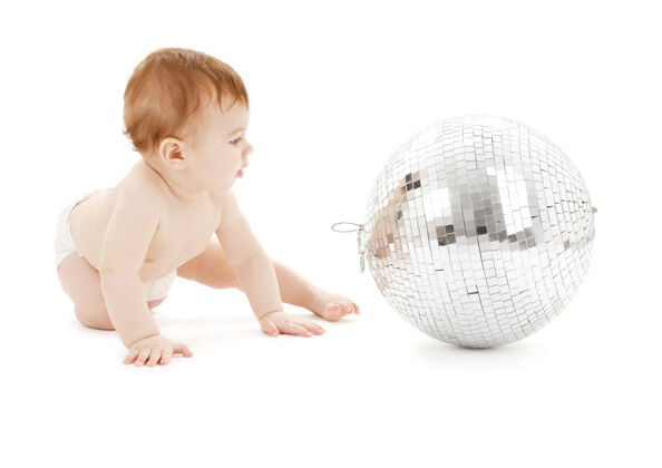 玩耍可爱的男婴和大迪斯科球超过白色天真幼儿新生儿