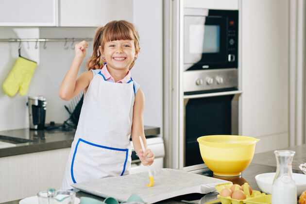 烘焙快乐的未成年少女的画像 在把面团放在烤盘上之前 用柔软的黄油覆盖烤盘食物准备软准备