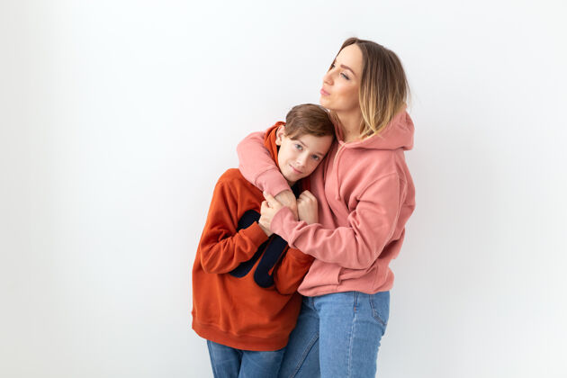 积极母亲节 孩子和家庭的概念-十几岁的男孩拥抱他的母亲在白色的表面保护10关注
