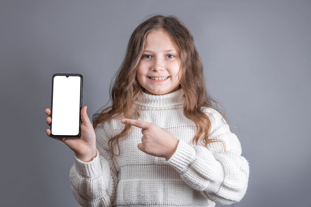 无线一个年轻漂亮的小女孩 金发飘逸 穿着白色毛衣 手持一部手机成人移动通信