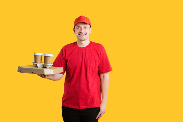 帽子一个戴着红帽子 穿着t恤的快递员手里拿着盒子和咖啡制服饮料外卖