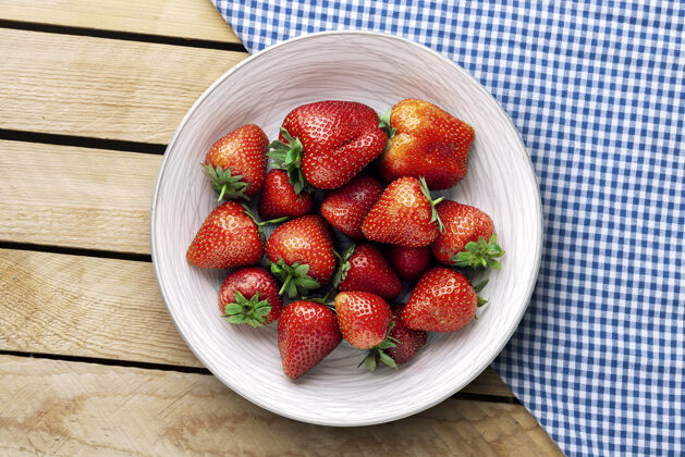 有机美味多汁的草莓放在木制背景的盘子里多汁的甜点生的
