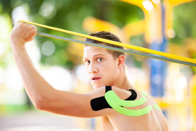 康复裸体肌肉男训练与健身阻力带在公园和运动场的背景成人活动腹肌