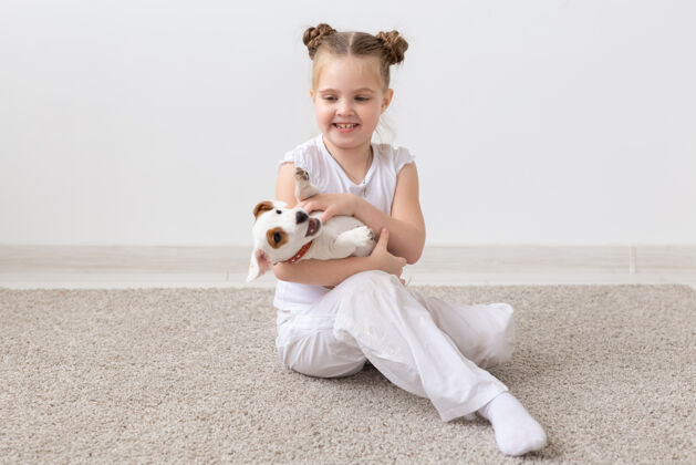 玩小女孩和小狗坐在地板上的画像狗衬衫宠物