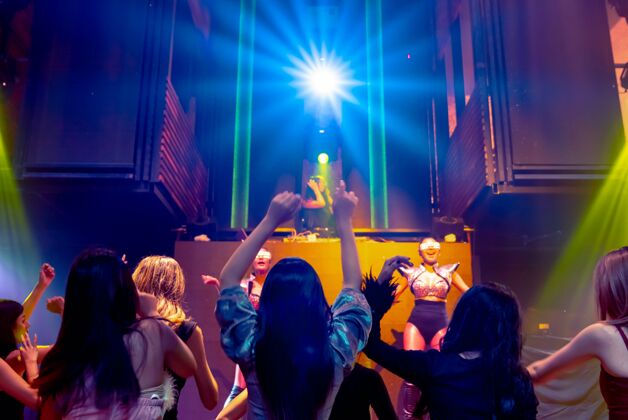 庆典一群人随着舞台上dj的音乐节拍在迪斯科夜总会跳舞青年俱乐部音乐