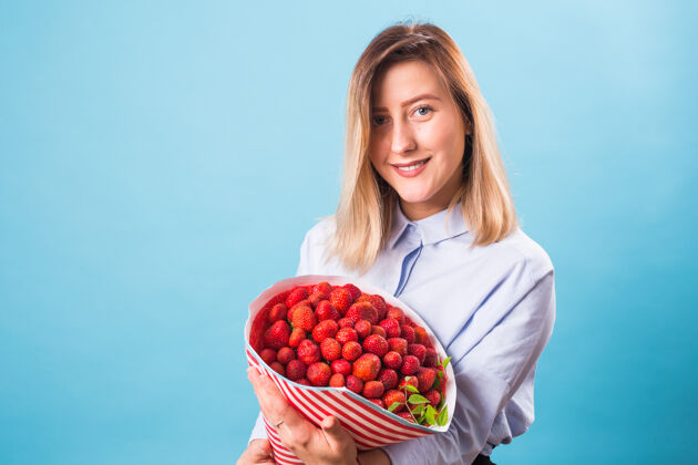 农场拿着一束草莓的年轻女人有机食物女性