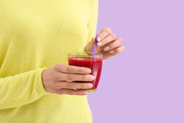 膳食在彩色表面上涂上一杯健康冰沙的女人自制排毒配料