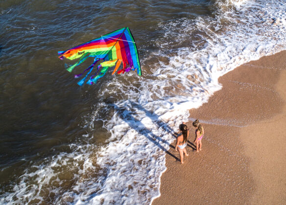 跑步两个女孩在海边玩风筝女儿妈妈蛇