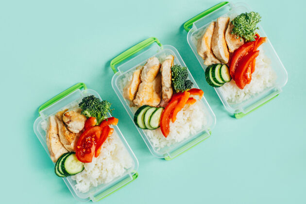 红辣椒浅绿色背景上的塑料碗中的蔬菜 米饭 肉的俯视图划船煮饭午餐盒