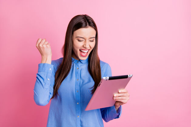 微笑尖叫的照片 欣喜若狂的女人拿着平板电脑女性评论时尚
