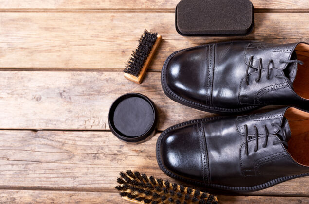 擦亮黑色男鞋与护理配件的木制背景穿配件靴子