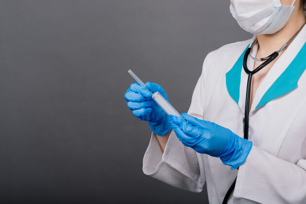 女性严肃的女医生戴着医用口罩拿着注射器和疫苗隔离在灰色上医生年轻人妇女