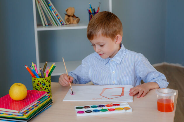 男孩小男孩在家里的桌子上画画刷子油漆桌子