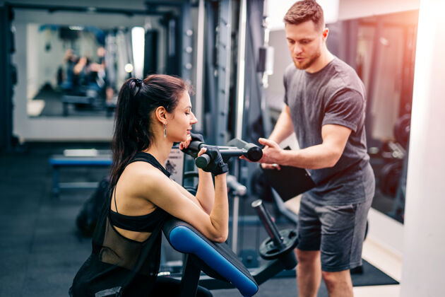 男人健身女士在健身房和教练一起锻炼护理正确个人