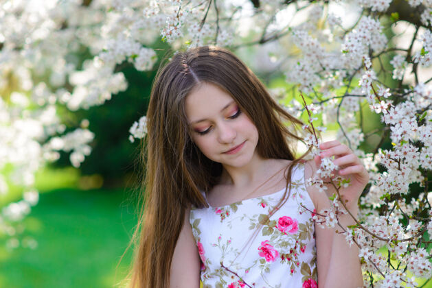 金发美丽的春天 美丽的小女孩在盛开的苹果园里孩子小公园