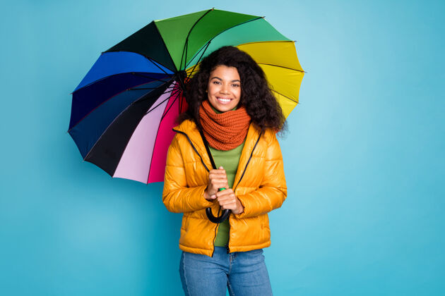 非洲人美丽的深色皮肤女士站在蓝色背景上 带着雨伞多国非洲人雨伞