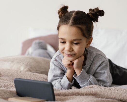 室内躺在床上看手机视频的女孩孩子设备小玩意