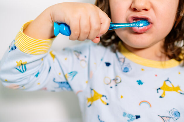 就寝时间睡前穿着睡衣用牙刷刷牙的小孩的嘴刷牙学前班生活方式