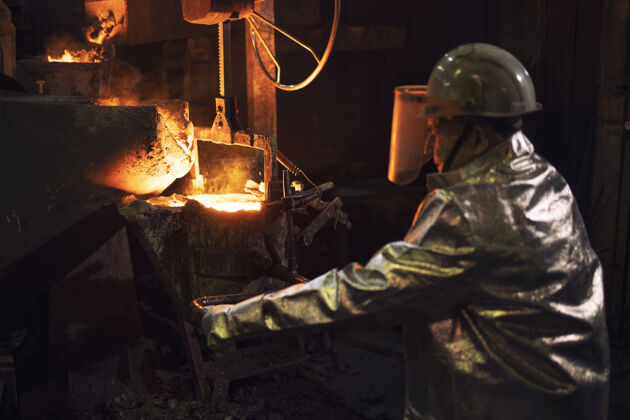 创始人方正穿着防护服在铸造厂里和热钢水一起工作员工铝制造