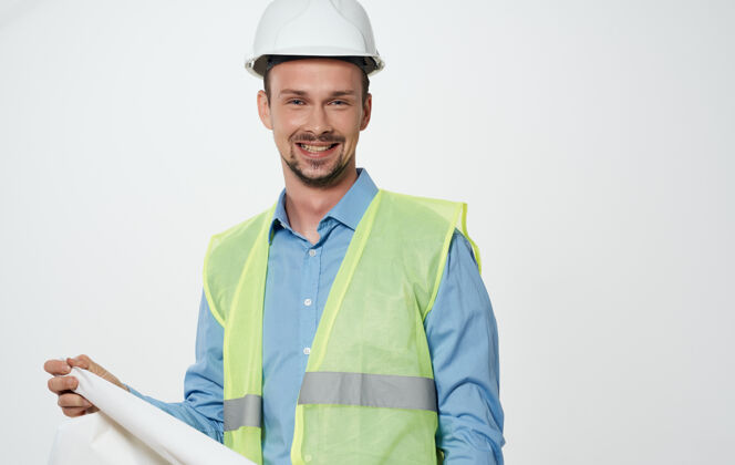 头盔一位男性土木工程师 手里拿着一卷纸 头上戴着一顶白色安全帽施工努力建筑