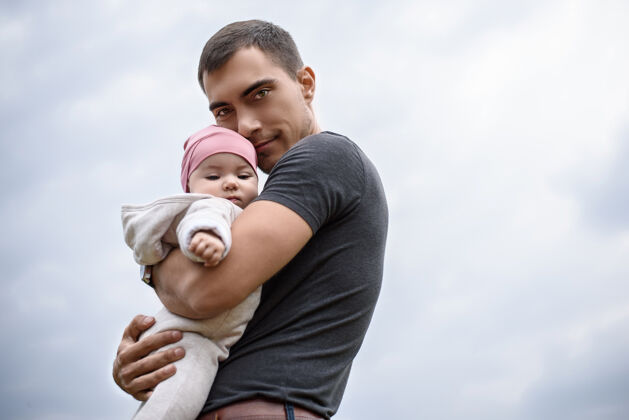 女婴爸爸抱着宝宝在新鲜空气里 和宝宝一起散步快乐单身父亲在一起