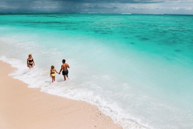 男人一个年轻漂亮的家庭带着一个孩子在热带雨林里毛里求斯度假酒店小岛海洋海洋度假