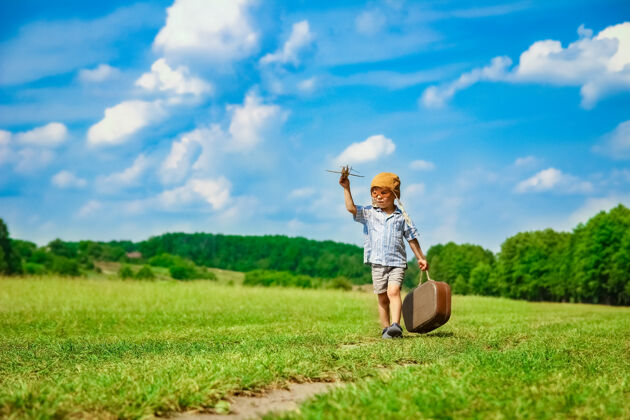 生活方式飞机旁的一个男婴在空中玩弄大自然公园男孩度假飞行员男孩游戏想法