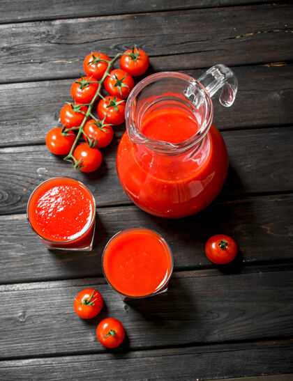 成熟番茄汁放在罐子里 成熟的番茄放在木桌上的树枝上果汁多汁蔬菜